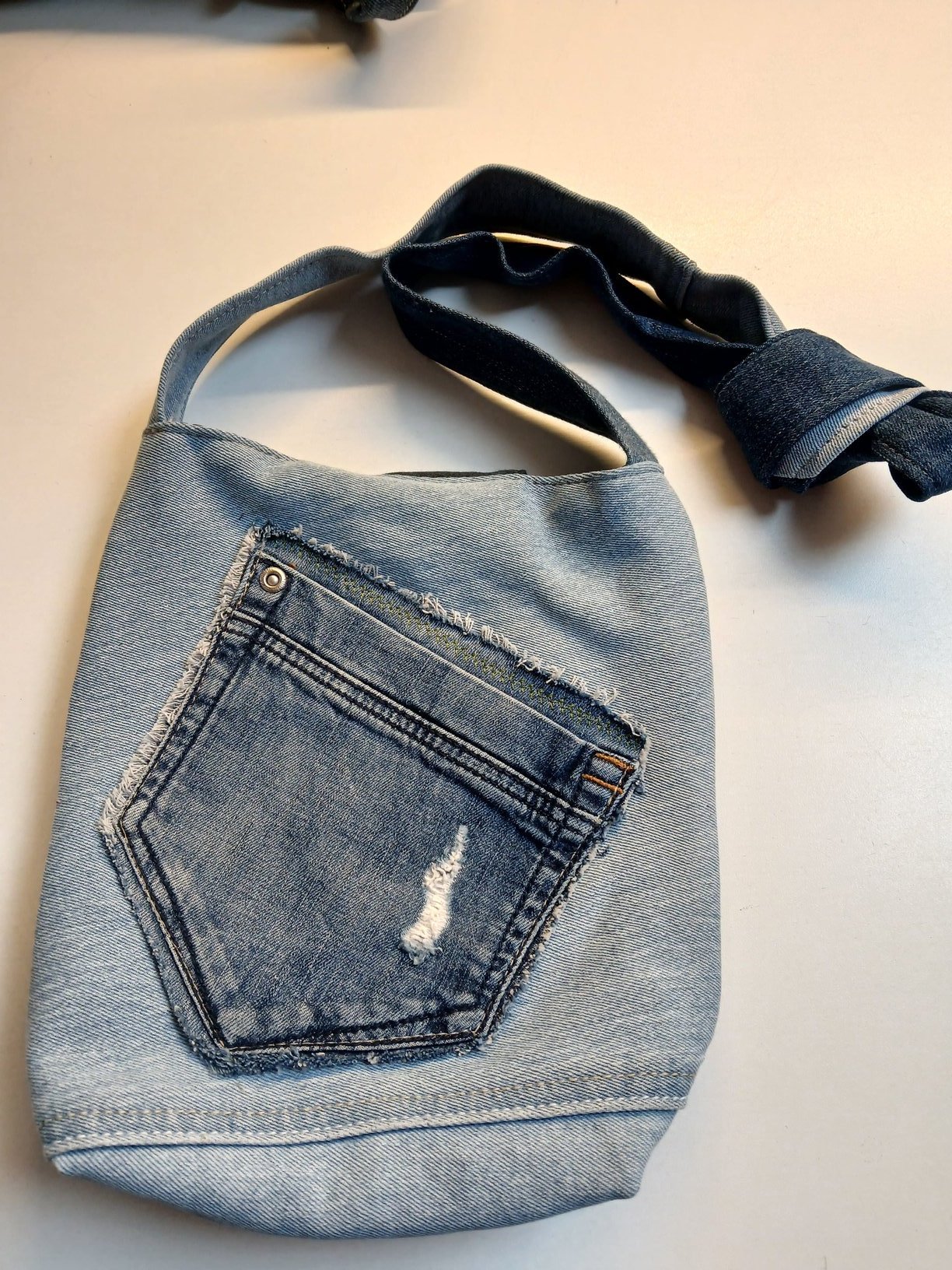 Lichte denim tas met versleten broekzak