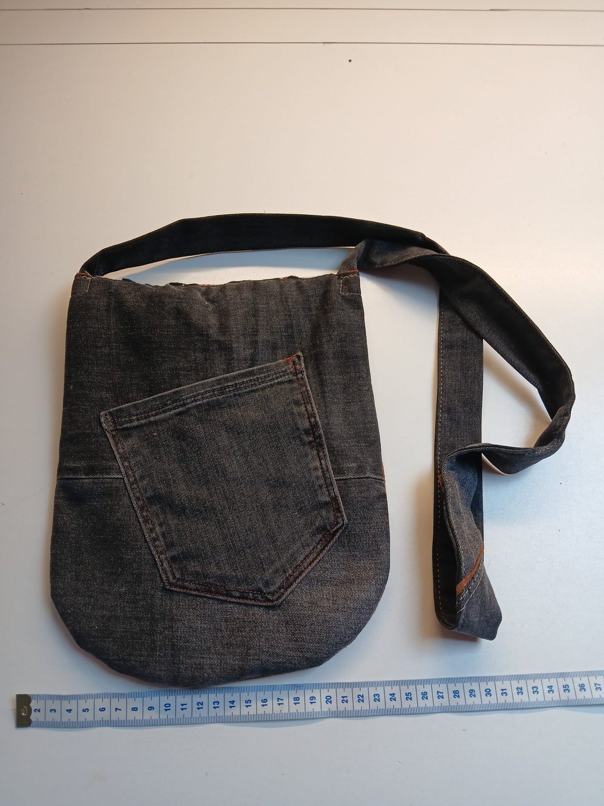 Donkere denim tas met grote achterzak