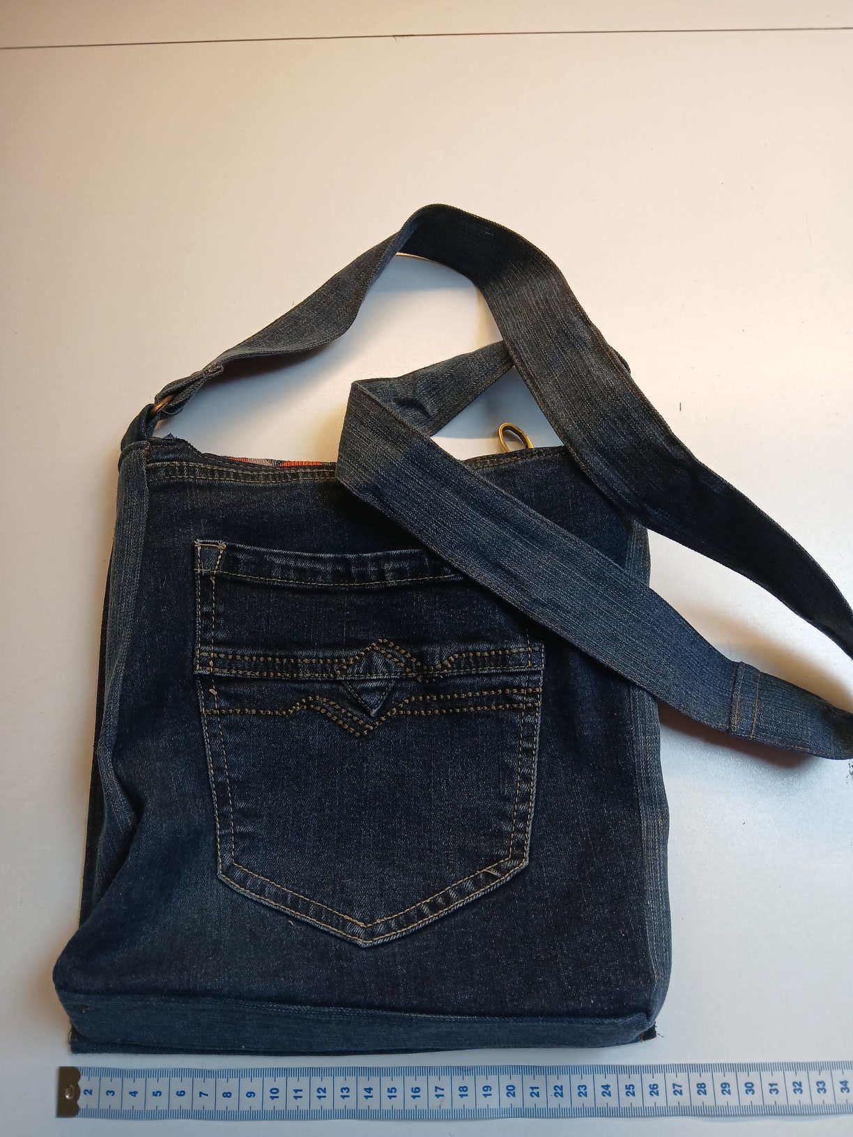 Donkerblauwe denim messenger met grote achterzak