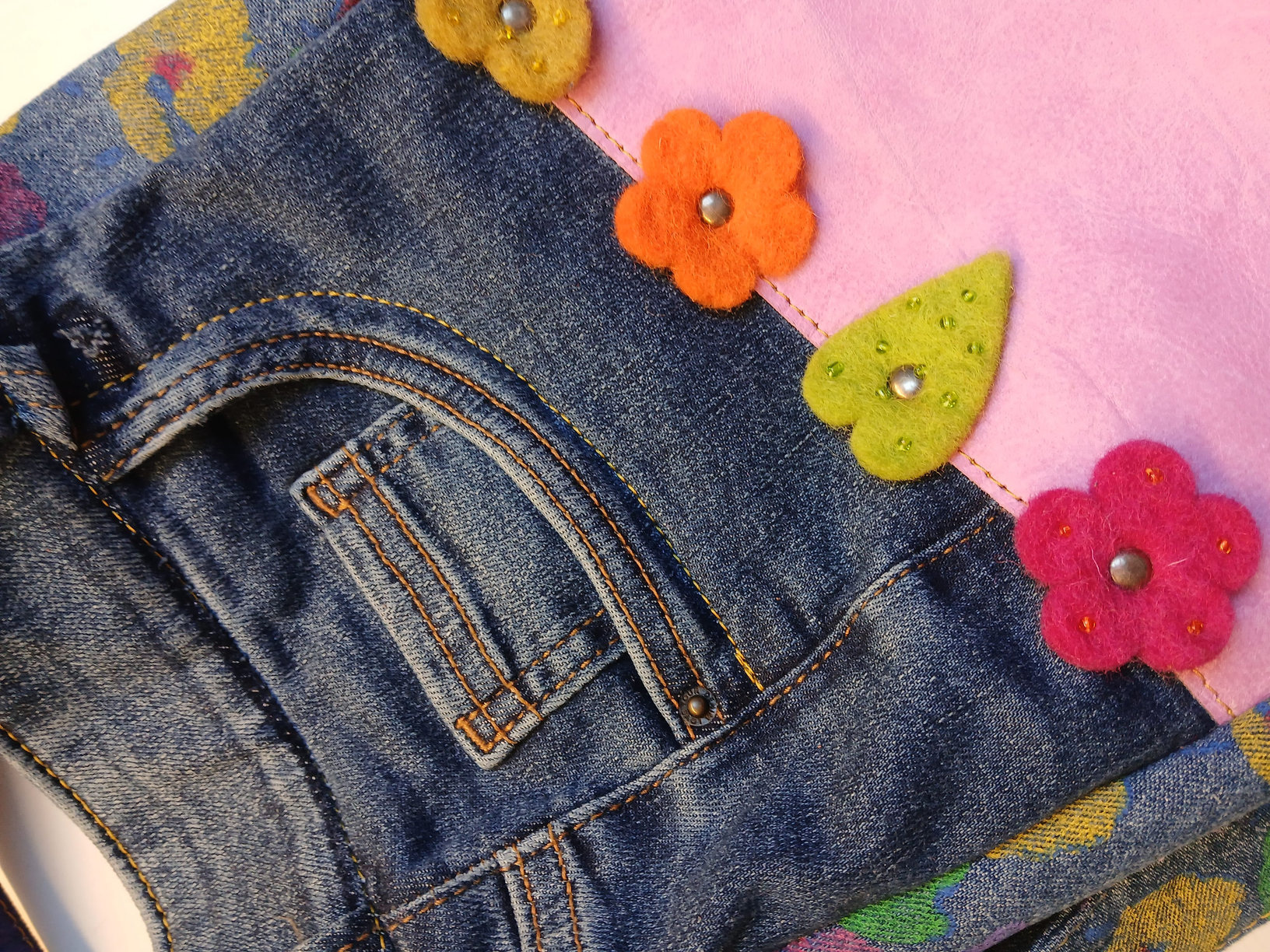 Detail — gevilte bloemetjes op denim