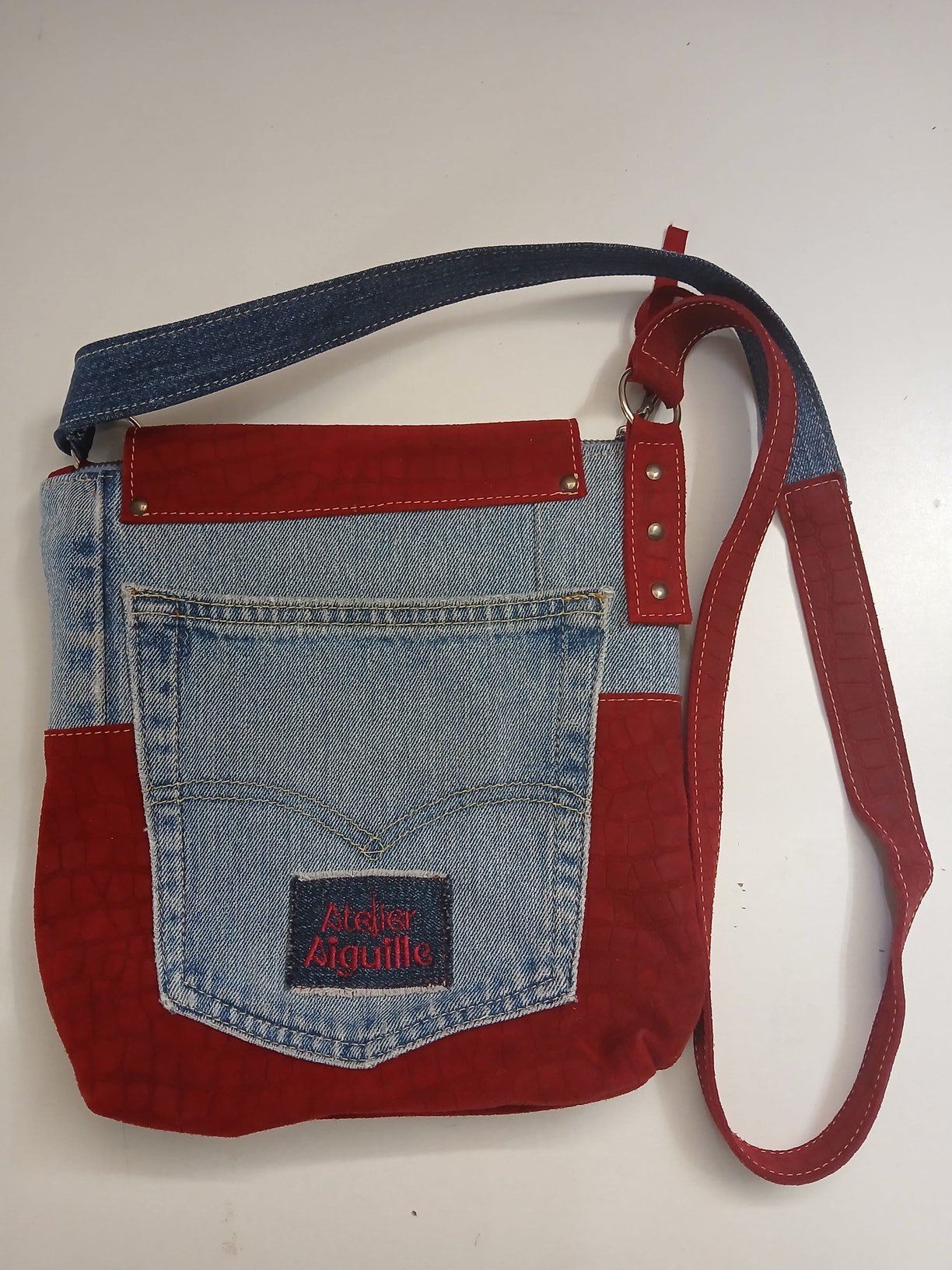 Rode tas met denim en geborduurd label