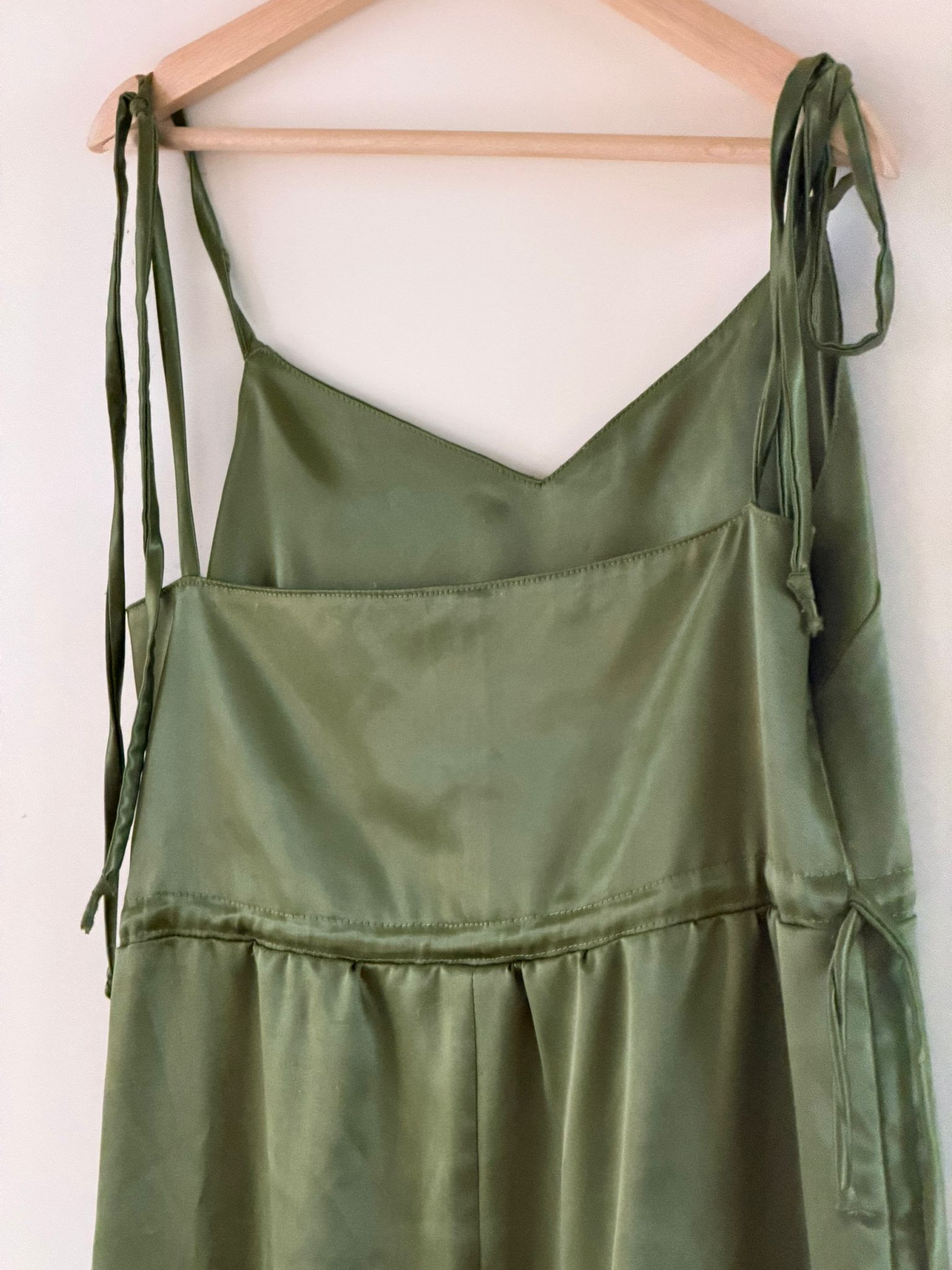 Groene satijnen jurk op hanger